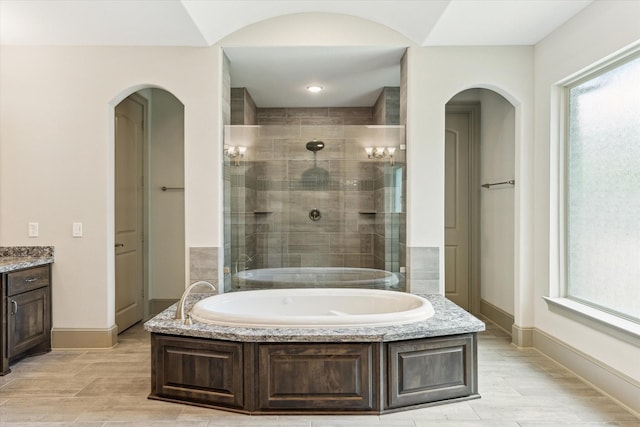 12710 Pebblebrook Dr, Houston, TX 77024 - bathroom with a bath, a stall shower, vanity, baseboards, and wood finished floors