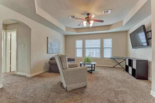25322 Metzler Creek Dr, Spring, TX 77389 - living area featuring carpet flooring, a tray ceiling, a ceiling fan, arched walkways, and baseboards