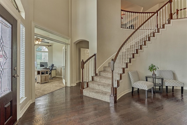 25322 Metzler Creek Dr, Spring, TX 77389 - foyer entrance featuring arched walkways, wood finished floors, stairway, baseboards, and a high ceiling