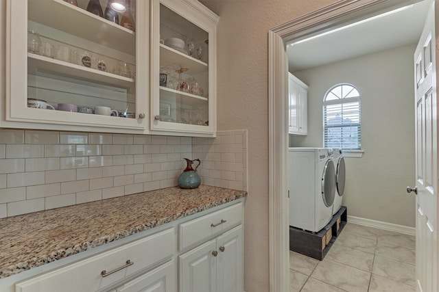 25322 Metzler Creek Dr, Spring, TX 77389 - laundry room featuring cabinet space, washing machine and dryer, light tile patterned flooring, and baseboards