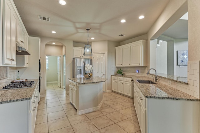 25322 Metzler Creek Dr, Spring, TX 77389 - kitchen with stainless steel appliances, a sink, backsplash, arched walkways, and recessed lighting