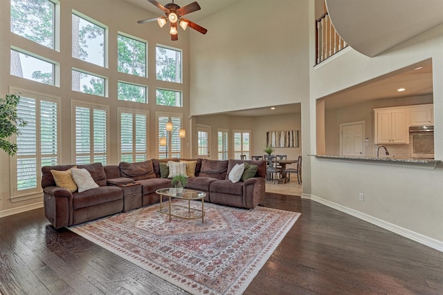 25322 Metzler Creek Dr, Spring, TX 77389 - living room with ceiling fan, plenty of natural light, dark wood-style flooring, baseboards, and a towering ceiling