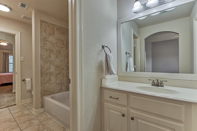 25322 Metzler Creek Dr, Spring, TX 77389 - bathroom featuring vanity, connected bathroom, a textured wall, and shower / washtub combination