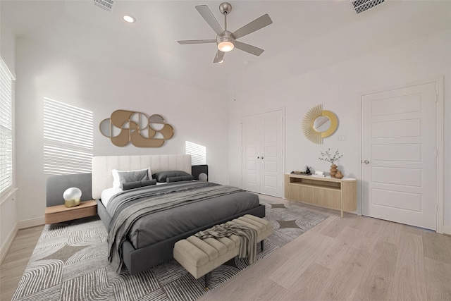 8918 Grovner Pl, Houston, TX 77055 - bedroom with light wood-style flooring, multiple windows, a ceiling fan, high vaulted ceiling, and baseboards