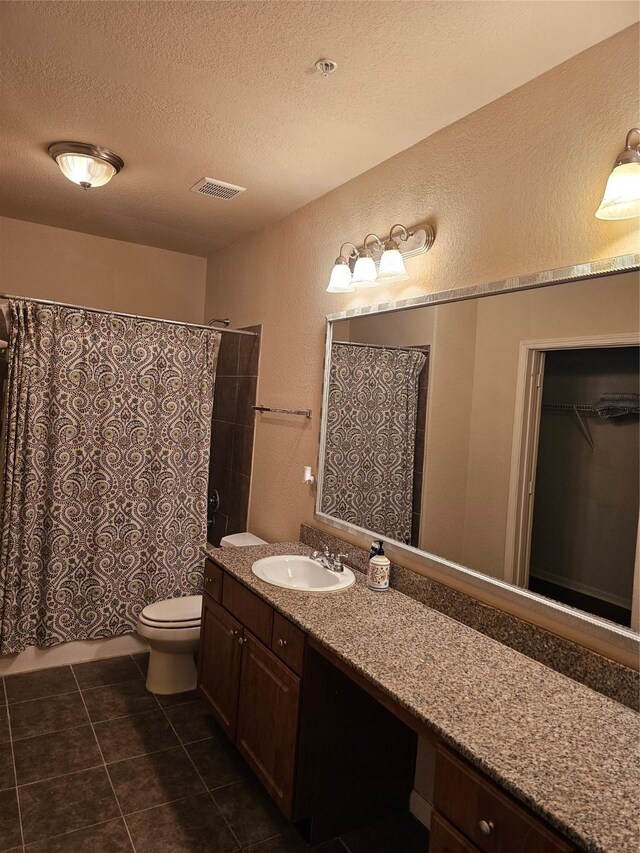 1711 Old Spanish Trl Unit 313, Houston, TX 77054 - bathroom with a textured wall, vanity, a textured ceiling, toilet, and tile patterned flooring