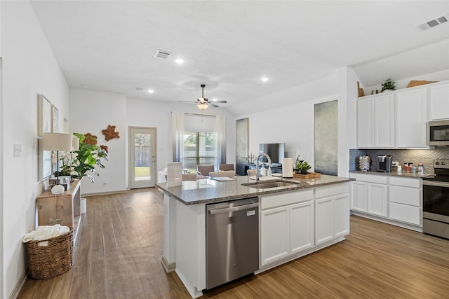 204 Shoreview Dr, Conroe, TX 77303 - kitchen with appliances with stainless steel finishes, a sink, open floor plan, an island with sink, and light wood-type flooring