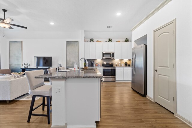 204 Shoreview Dr, Conroe, TX 77303 - kitchen featuring stainless steel appliances, a sink, open floor plan, a breakfast bar, and ceiling fan