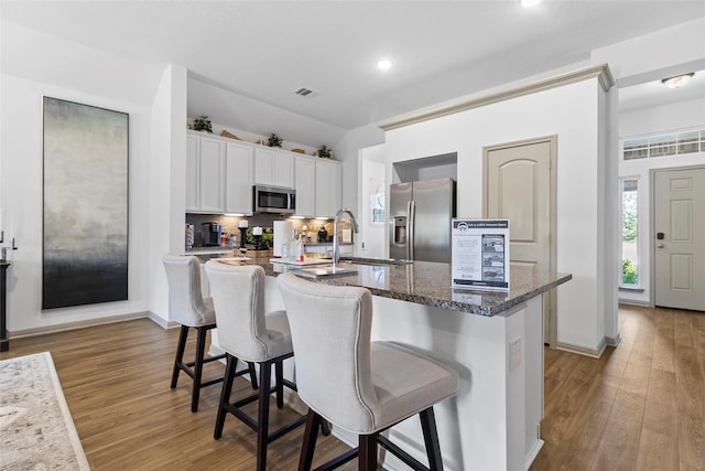 204 Shoreview Dr, Conroe, TX 77303 - kitchen featuring appliances with stainless steel finishes, a sink, a kitchen breakfast bar, a center island with sink, and light wood-type flooring