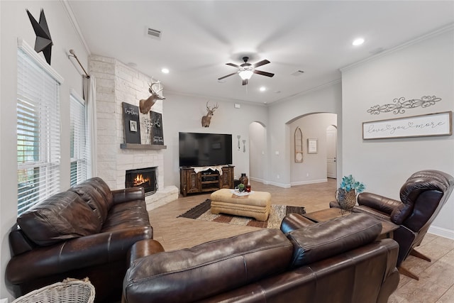 28026 Chuckwagon Trl, Magnolia, TX 77355 - living room with arched walkways, ceiling fan, crown molding, baseboards, and a stone fireplace