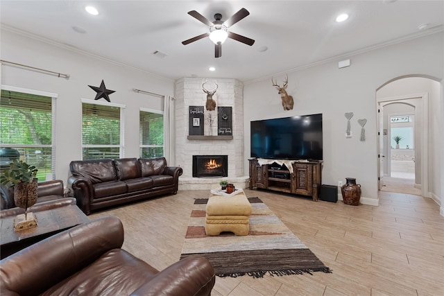 28026 Chuckwagon Trl, Magnolia, TX 77355 - living room with ceiling fan, plenty of natural light, arched walkways, ornamental molding, and a stone fireplace