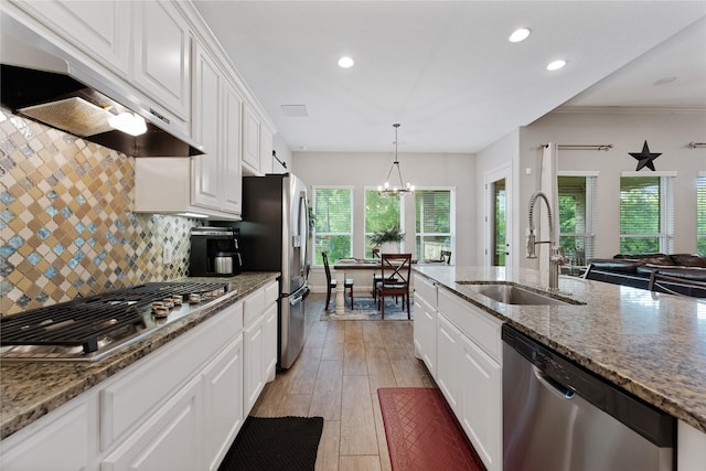 28026 Chuckwagon Trl, Magnolia, TX 77355 - kitchen with stainless steel appliances, exhaust hood, a sink, recessed lighting, and white cabinetry