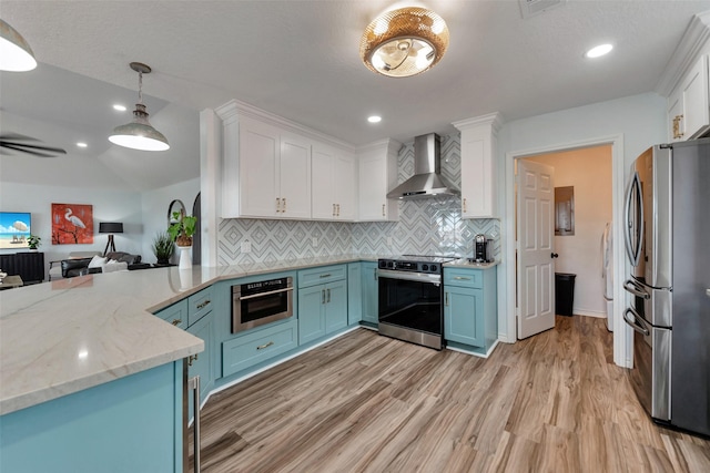 1427 Bamboo Dr, Tiki Island, TX 77554 - kitchen featuring wall chimney exhaust hood, stainless steel appliances, blue cabinetry, white cabinetry, and light wood-style floors