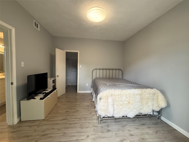 8149 Sands Point Dr Unit 113, Houston, TX 77036 - bedroom with wood finished floors, baseboards, and a textured ceiling
