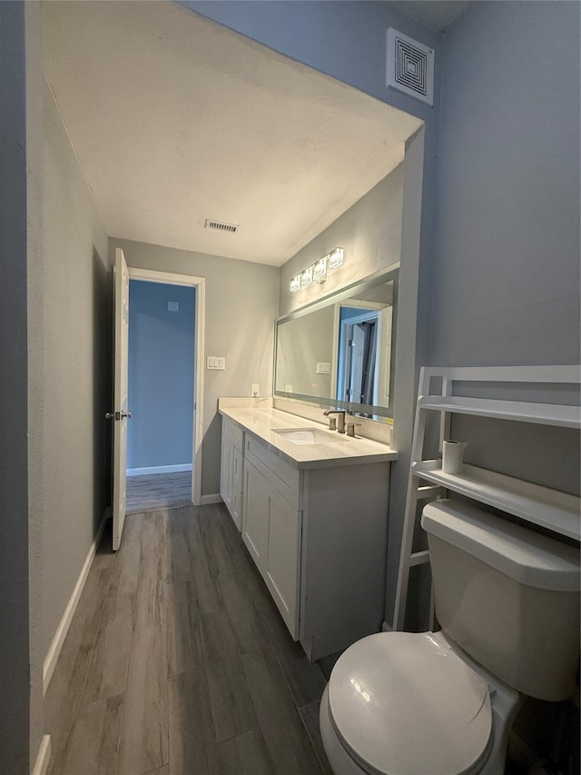 8149 Sands Point Dr Unit 113, Houston, TX 77036 - bathroom with toilet, vanity, wood finished floors, and baseboards