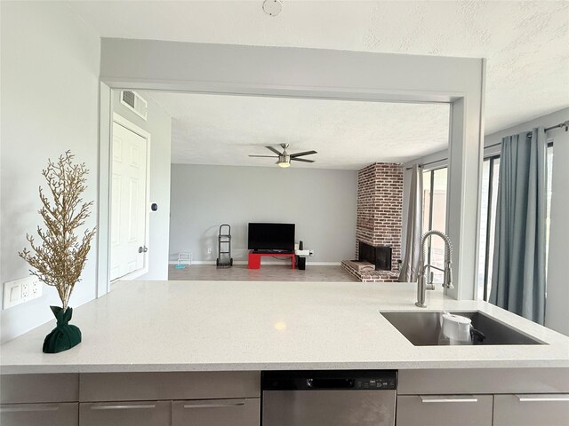 8149 Sands Point Dr Unit 113, Houston, TX 77036 - kitchen featuring a sink, dishwasher, gray cabinetry, a ceiling fan, and a brick fireplace