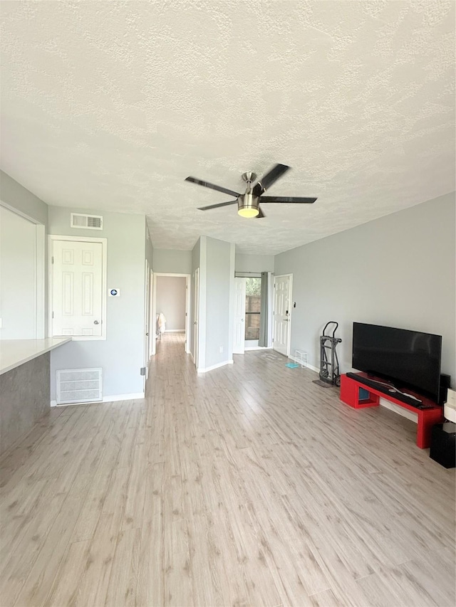 8149 Sands Point Dr Unit 113, Houston, TX 77036 - unfurnished living room with a textured ceiling, a ceiling fan, wood finished floors, and baseboards