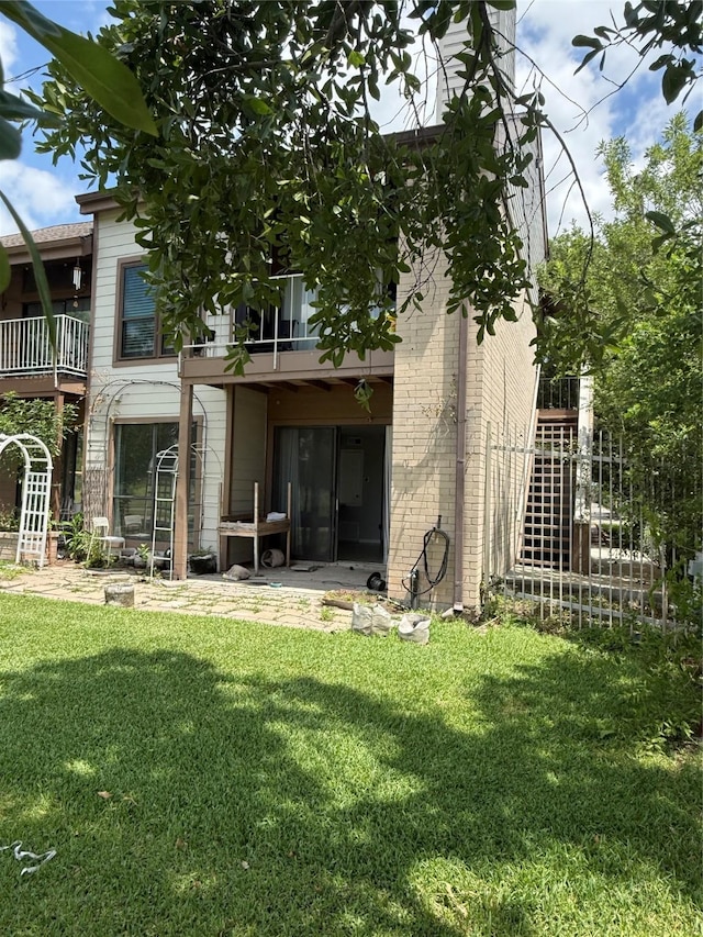 8149 Sands Point Dr Unit 113, Houston, TX 77036 - rear view of house with a balcony, a lawn, and brick siding