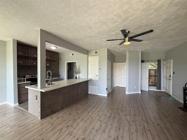 8149 Sands Point Dr Unit 113, Houston, TX 77036 - kitchen with wood finished floors, baseboards, light countertops, ceiling fan, and stainless steel electric range