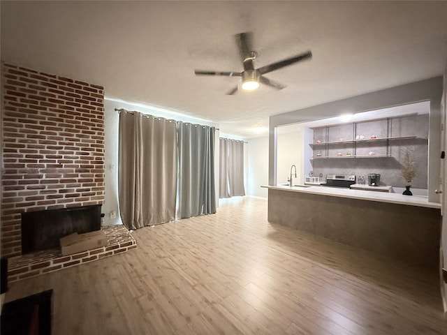 8149 Sands Point Dr Unit 113, Houston, TX 77036 - living area with a ceiling fan, wood finished floors, a brick fireplace, and brick wall