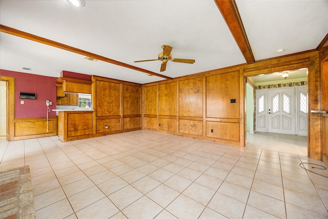 4923 Bradstone Ct, Houston, TX 77084 - unfurnished living room with a ceiling fan, wood walls, beamed ceiling, and light tile patterned floors