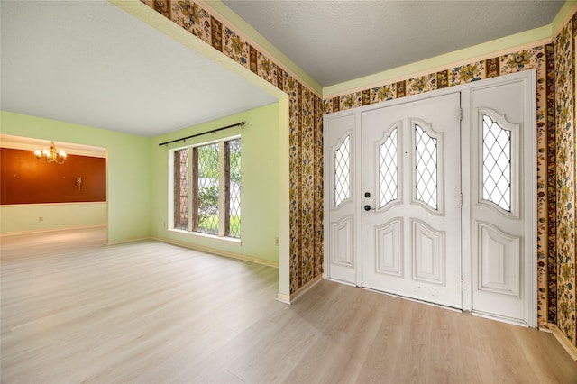 4923 Bradstone Ct, Houston, TX 77084 - entrance foyer with a chandelier, baseboards, wood finished floors, wallpapered walls, and a textured ceiling