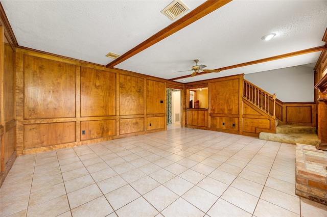 4923 Bradstone Ct, Houston, TX 77084 - unfurnished living room featuring a ceiling fan, wooden walls, a textured ceiling, stairs, and crown molding
