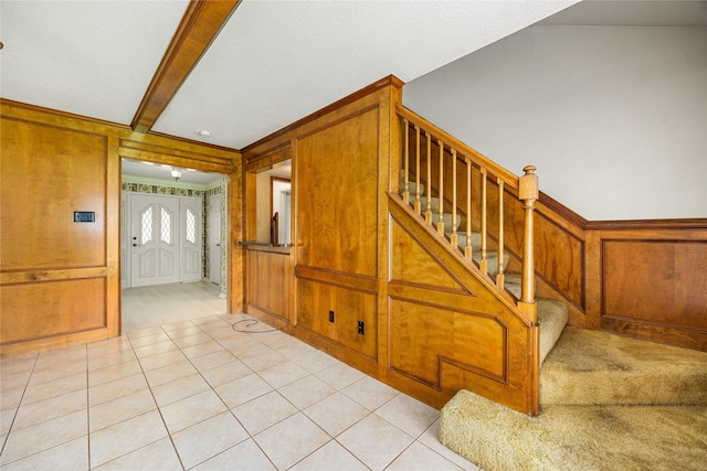 4923 Bradstone Ct, Houston, TX 77084 - stairs featuring carpet floors, tile patterned floors, wooden walls, and beamed ceiling