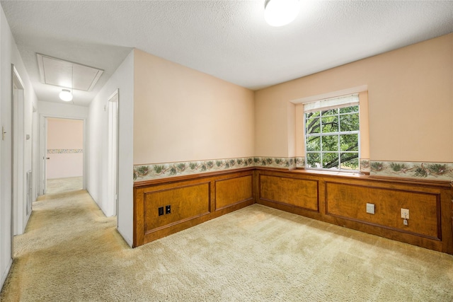 4923 Bradstone Ct, Houston, TX 77084 - empty room featuring attic access, light carpet, wainscoting, and a textured ceiling