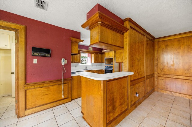 4923 Bradstone Ct, Houston, TX 77084 - kitchen with black oven, a sink, light countertops, light tile patterned floors, and a textured ceiling