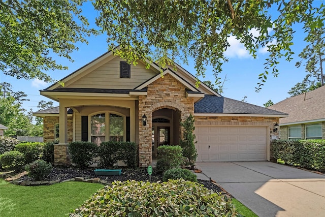 7 Fraiser Fir Pl, Spring, TX 77389 - view of front of home featuring stone siding, a garage, concrete driveway, and roof with shingles