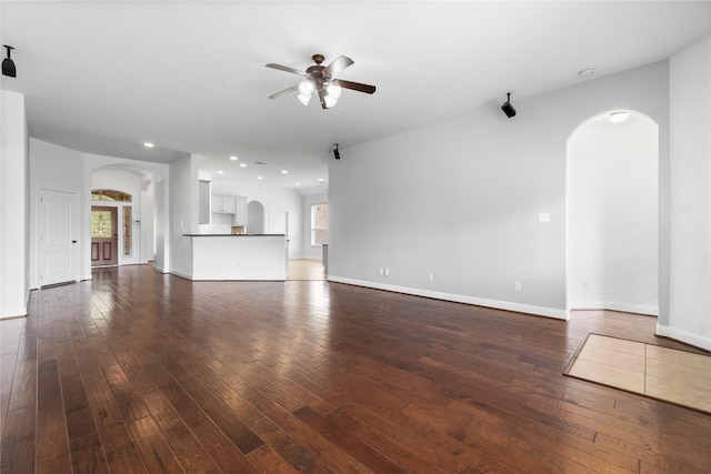 7 Fraiser Fir Pl, Spring, TX 77389 - unfurnished living room featuring arched walkways, ceiling fan, dark wood-style floors, baseboards, and recessed lighting