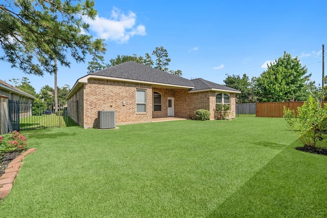 7 Fraiser Fir Pl, Spring, TX 77389 - back of property featuring central AC, brick siding, and a shingled roof
