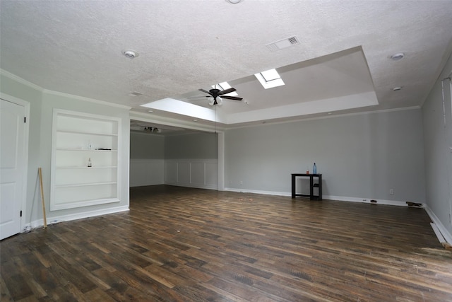 5952 Moonstone St, Port Arthur, TX 77640 - empty room featuring dark wood finished floors, a textured ceiling, built in features, a tray ceiling, and a ceiling fan
