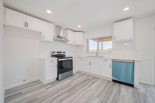 413 E Castle Harbour Dr W, Friendswood, TX 77546 - kitchen featuring wall chimney exhaust hood, stainless steel appliances, a sink, light wood-style flooring, and white cabinetry