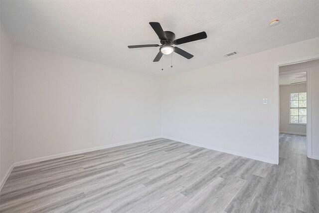 413 E Castle Harbour Dr W, Friendswood, TX 77546 - empty room featuring light wood-style flooring, ceiling fan, baseboards, and a textured ceiling