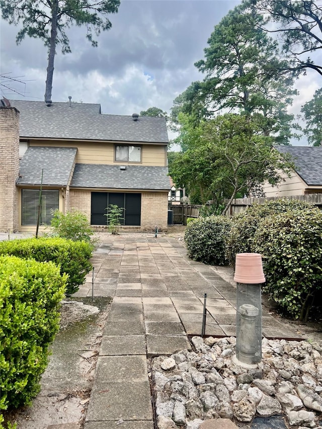 6523 Coral Ridge Rd, Houston, TX 77069 - view of side of home featuring a patio, brick siding, and a shingled roof