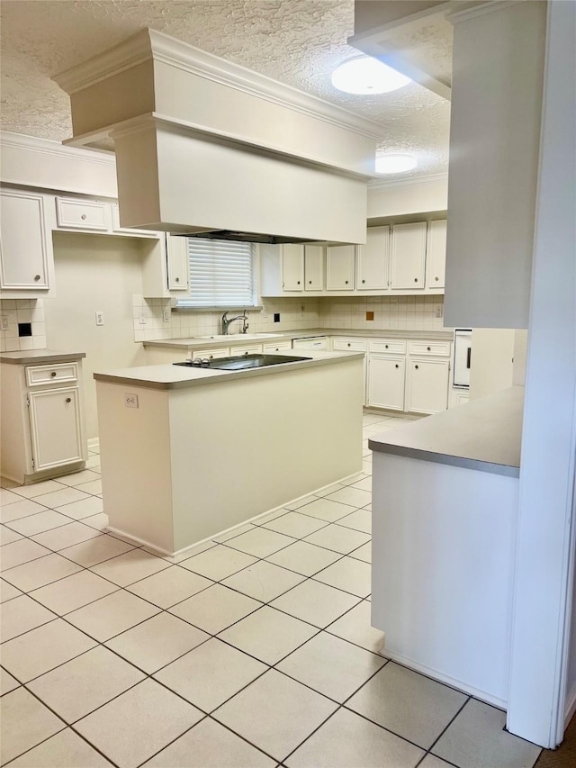 6523 Coral Ridge Rd, Houston, TX 77069 - kitchen with a textured ceiling, crown molding, tasteful backsplash, light tile patterned floors, and white cabinetry