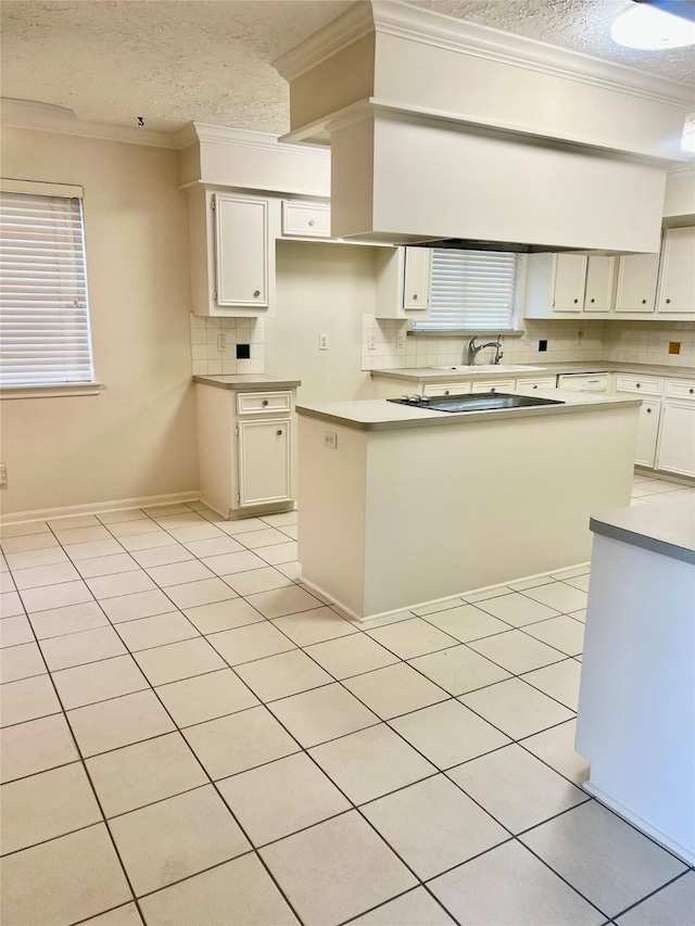 6523 Coral Ridge Rd, Houston, TX 77069 - kitchen with decorative backsplash, crown molding, a textured ceiling, light countertops, and white cabinetry