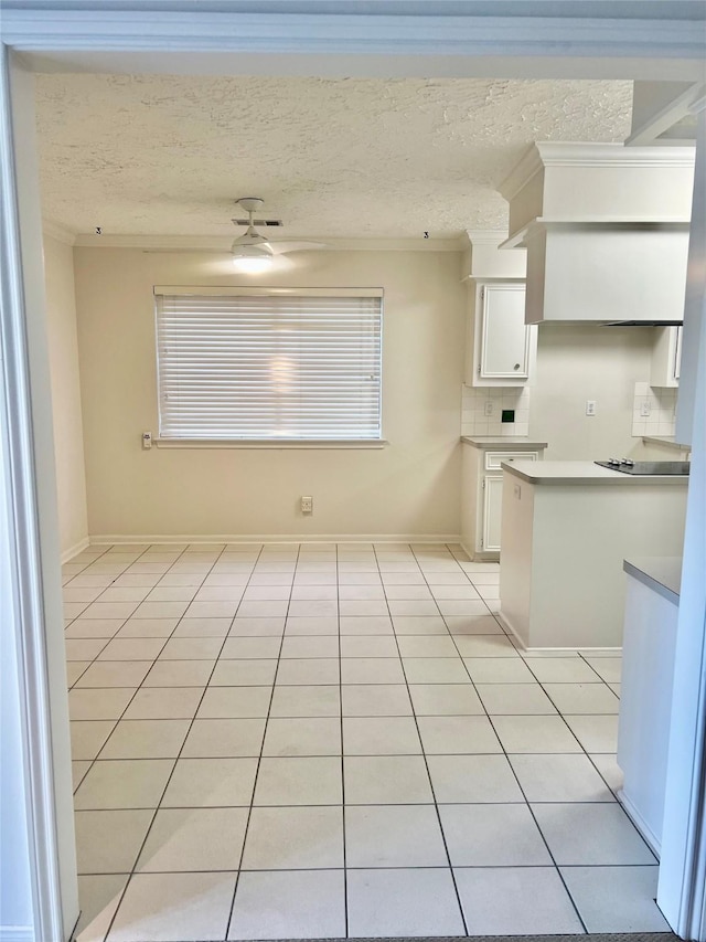 6523 Coral Ridge Rd, Houston, TX 77069 - kitchen featuring white cabinetry, crown molding, light tile patterned flooring, decorative backsplash, and a textured ceiling
