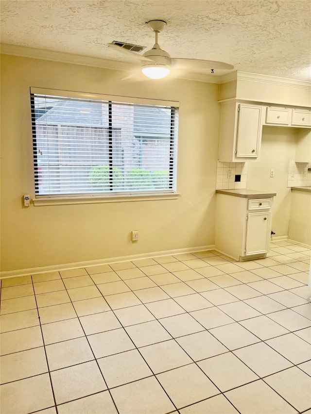 6523 Coral Ridge Rd, Houston, TX 77069 - unfurnished dining area featuring ornamental molding, plenty of natural light, a textured ceiling, light tile patterned floors, and baseboards