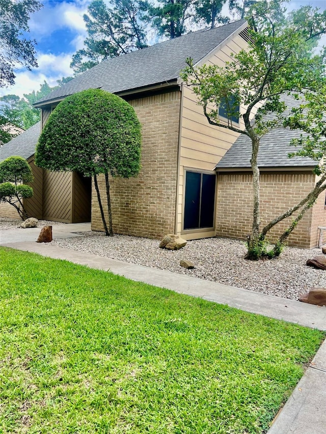 6523 Coral Ridge Rd, Houston, TX 77069 - view of side of property featuring a shingled roof, brick siding, and a lawn