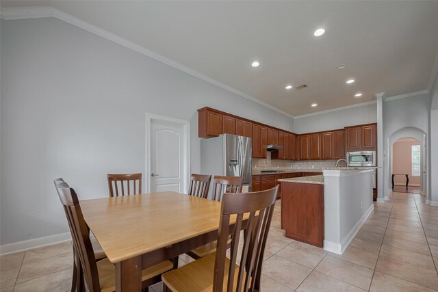 14727 Bronze Finch Dr, Cypress, TX 77433 - dining room featuring light tile patterned floors, arched walkways, recessed lighting, baseboards, and crown molding