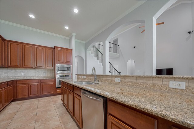 14727 Bronze Finch Dr, Cypress, TX 77433 - kitchen with stainless steel appliances, a sink, ornamental molding, decorative backsplash, and light stone countertops