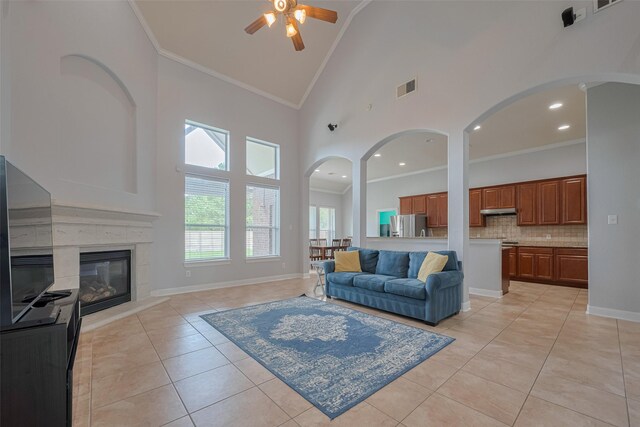14727 Bronze Finch Dr, Cypress, TX 77433 - living area featuring a ceiling fan, crown molding, light tile patterned floors, high vaulted ceiling, and baseboards