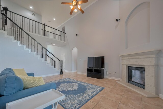 14727 Bronze Finch Dr, Cypress, TX 77433 - living area featuring high vaulted ceiling, ceiling fan, arched walkways, stairway, and light tile patterned floors