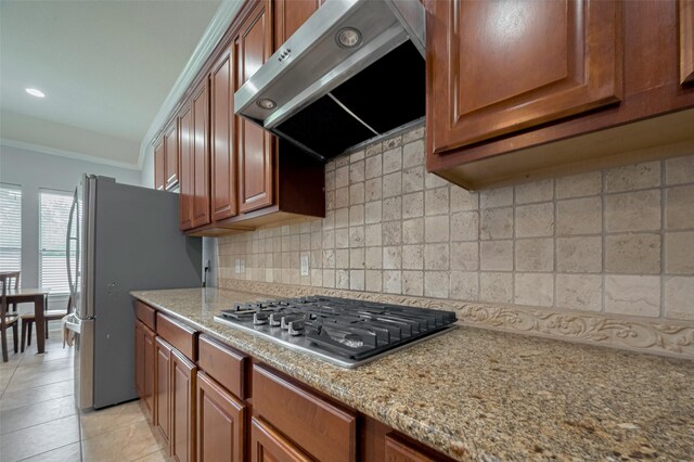 14727 Bronze Finch Dr, Cypress, TX 77433 - kitchen featuring under cabinet range hood, stainless steel appliances, brown cabinets, tasteful backsplash, and ornamental molding