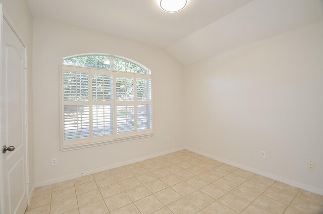 15111 Crescent Lilly Dr, Cypress, TX 77433 - empty room featuring vaulted ceiling, light tile patterned flooring, and baseboards