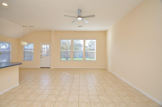 15111 Crescent Lilly Dr, Cypress, TX 77433 - unfurnished living room featuring light tile patterned floors, ceiling fan, healthy amount of natural light, baseboards, and vaulted ceiling