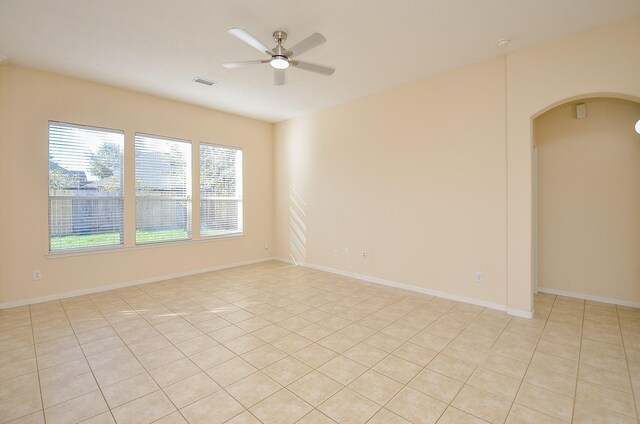 15111 Crescent Lilly Dr, Cypress, TX 77433 - unfurnished room featuring arched walkways, ceiling fan, and light tile patterned floors