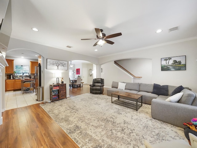 7106 Harmony Cv, Houston, TX 77036 - living room with arched walkways, ceiling fan, light wood finished floors, stairs, and recessed lighting